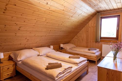 MichalováにあるChata Planinaの木造キャビン内のベッドルーム1室(ベッド2台付)