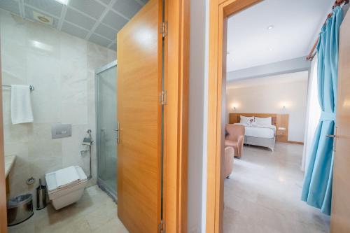 a bathroom with a shower and a bedroom at Majeste Hotel Bodrum in Bodrum City