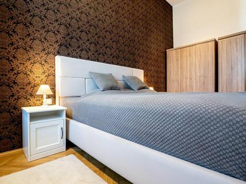 a bedroom with a large white bed and a night stand at Westend Apartment in Budapest