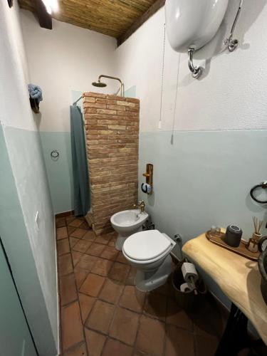 a bathroom with a toilet and a sink at Graziosa stanza campidanese Su segundu in Oristano