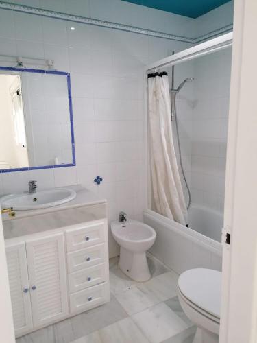 a white bathroom with a sink and a toilet at Casa con piscina privada in El Puerto de Santa María