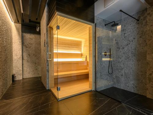 uma cabina de duche ao nível do chão numa casa de banho com uma porta de vidro em VisitZakopane- Toscana Apartment em Zakopane