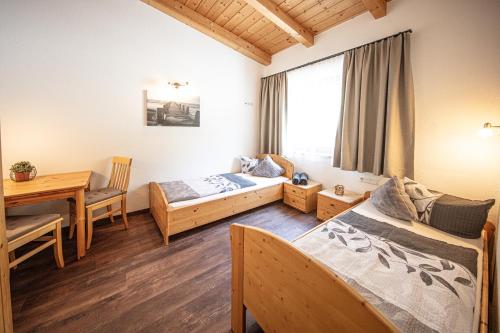 - une chambre avec 2 lits et une table à manger dans l'établissement Alpenapart Grüner, à Längenfeld