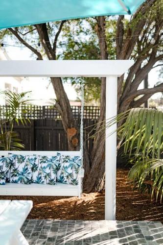 a white bench sitting under a blue umbrella at Steamers Bungalow in Huskisson