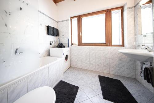 レンゲンフェルトにあるAlpenapart Grünerのバスルーム(バスタブ、洗面台、トイレ付)