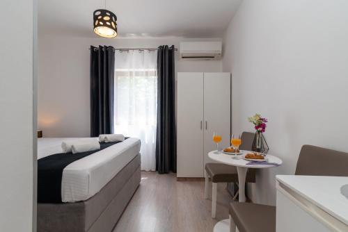 Habitación de hotel con cama y mesa con mesa en Apartments Bozan, en Trogir
