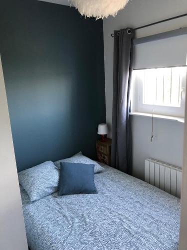 une chambre avec un lit bleu et une fenêtre dans l'établissement Petit Gîte de Javernières Rez de jardin, à Villié-Morgon