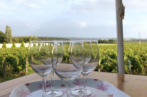 trois verres à vin assis sur une assiette sur une table dans l'établissement Petit Gîte de Javernières Rez de jardin, à Villié-Morgon