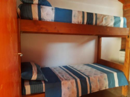 Cabañas El Colibrí في تريفيلين: سريرين بطابقين في غرفة مع سرير