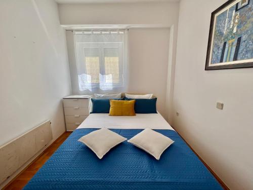 een slaapkamer met een blauw en wit bed met 2 kussens bij Apartman Salty Kisses in Crikvenica