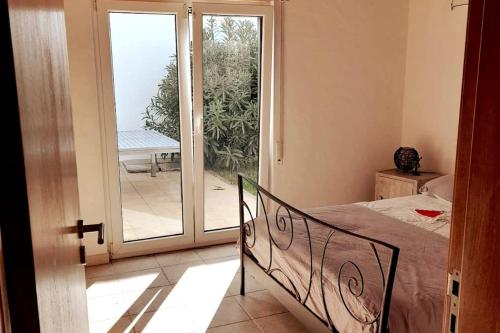 a bedroom with a bed and a sliding glass door at Le Vent Des Anges - The Wind of Angels in Sagres