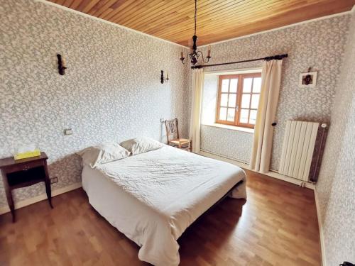 ein Schlafzimmer mit einem weißen Bett und einem Fenster in der Unterkunft Maison Encantalou 