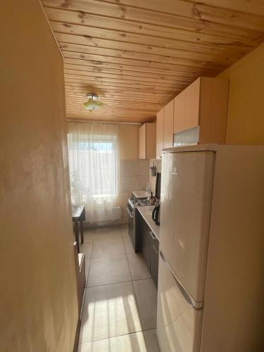a small kitchen with a refrigerator and a table at kvartira in Krāslava