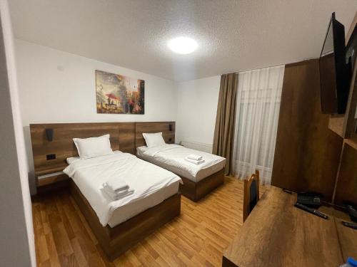 a hotel room with two beds and a television at Bici Resort in Dobrosin