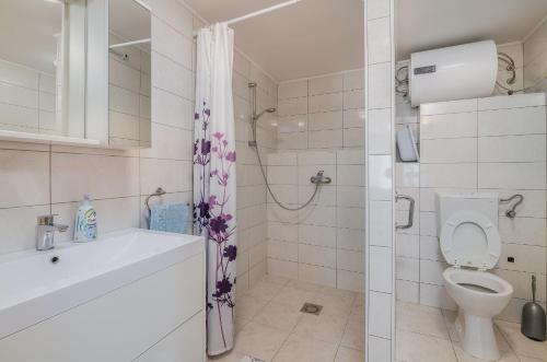 a bathroom with a toilet and a sink and a shower at Apartmani M in Baška