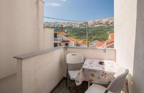 a small balcony with a table and chairs on it at Apartmani M in Baška