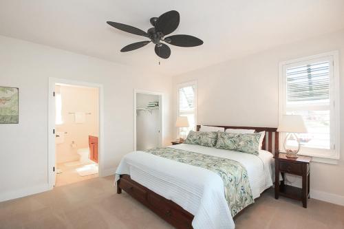 Un dormitorio con una cama y un ventilador de techo. en Pili Mai 15A, en Koloa