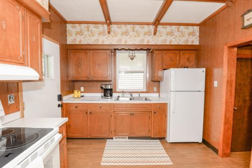 uma cozinha com armários de madeira e um frigorífico branco em Unique Two Story with a Vintage Flare em Fargo