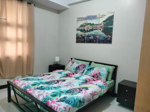 1 dormitorio con 1 cama y una pintura en la pared en Newport City Condo near Manila Airport Terminal 3, en Manila