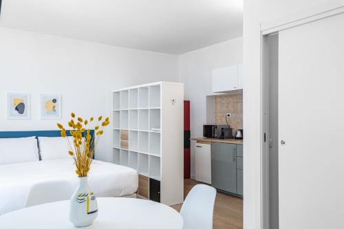 a room with a bed and a table and a kitchen at RELSTAY - Porta Romana - Large Studio in Milan