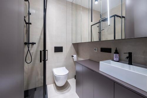 y baño con aseo, lavabo y ducha. en Apartament Piotrkowska 44 - studio, en Łódź