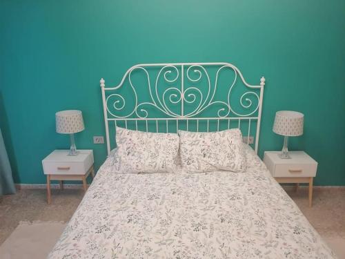 uma cama com uma cabeceira verde e duas mesas de cabeceira em Casa las pencas de margarita em Los Realejos