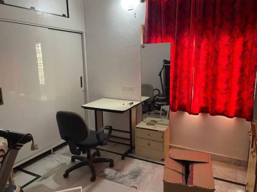 an office with a desk and a red curtain at City Style Cottage in Surūrnagar