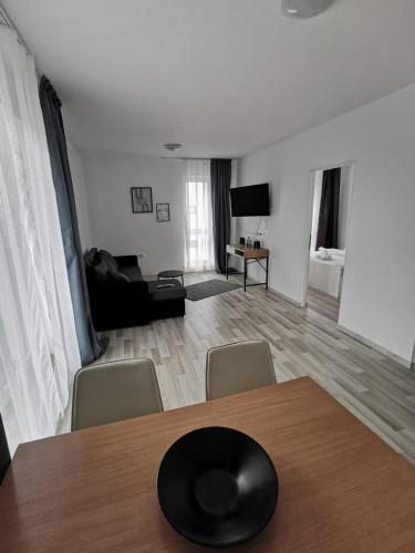 salon ze stołem i krzesłami oraz salon w obiekcie New Apartament Baia Mare 20 w mieście Baia Mare
