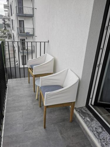 kilka krzeseł siedzących na balkonie w obiekcie New Apartament Baia Mare 20 w mieście Baia Mare