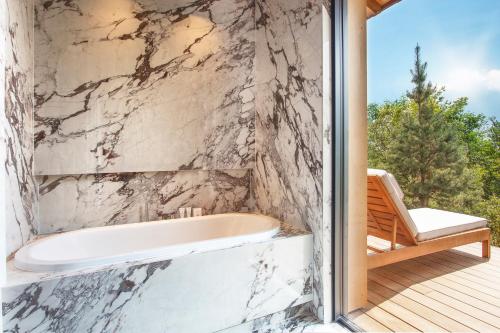a bath tub in a bathroom with a balcony at Jiva Hill Resort - Genève in Crozet