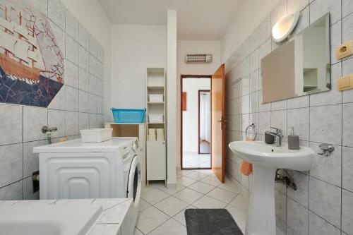 a bathroom with a washing machine and a sink at Guesthouse Aria in Trogir