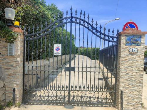 a black wrought iron gate with a stone driveway at Le Palme Vacanze in Trappeto