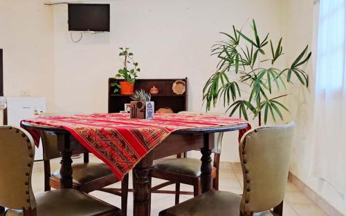 LatorrePAS Dpto في سالتا: طاولة طعام مع طاولة قماش وكراسي حمراء