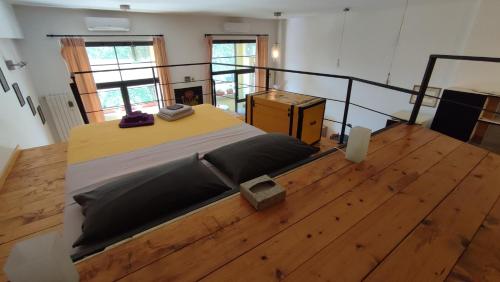 Cama grande en habitación con suelo de madera en la casa di amy - loft corvetto, en Milán