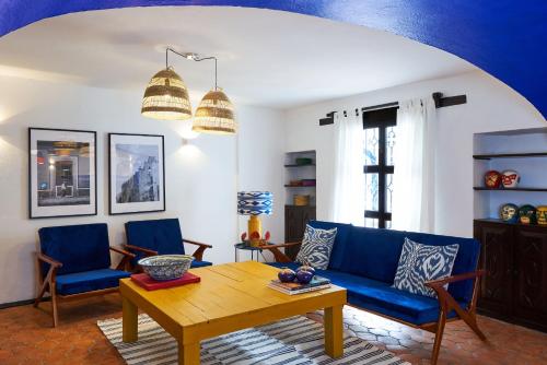 a living room with a blue couch and a wooden table at AmazINN Stay CDMX Coyoacan in Mexico City
