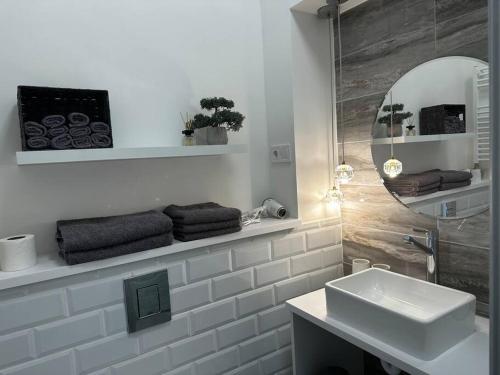 een witte badkamer met een wastafel en een spiegel bij Luxury downtown apartment in Boedapest