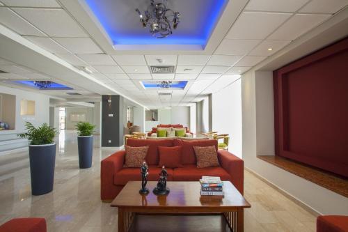 a living room with a red couch and a table at Mayfair Hotel in Paphos City