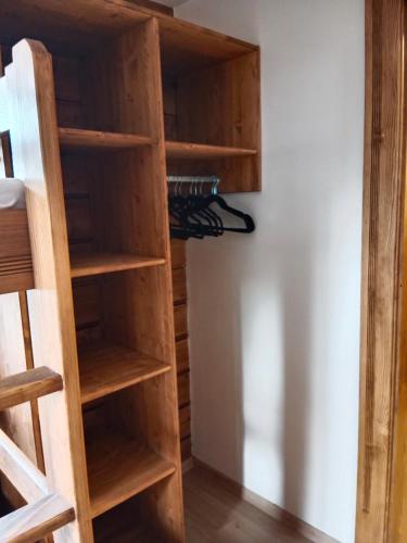 a closet with wooden shelves next to a wall at Horská bouda Krakonoš in Pec pod Sněžkou