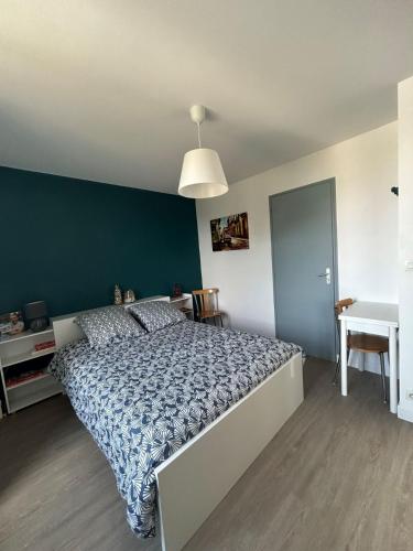 a bedroom with a large bed with a blue wall at L'escapade Clisson in Clisson