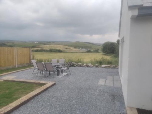a patio with a table and chairs and a field at The Cottage - Fairwinds in Doolin