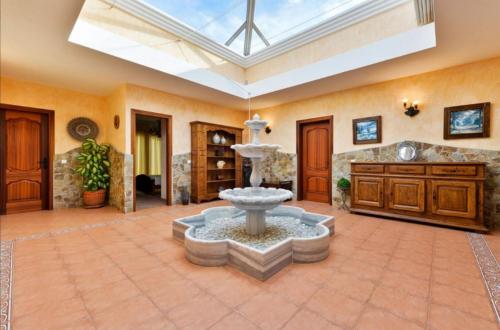 duży salon z fontanną w środku w obiekcie Villa Evie w mieście San Antonio