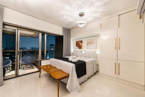 a bedroom with a bed and a balcony at Rosemari's Apartments Republica in Sao Paulo