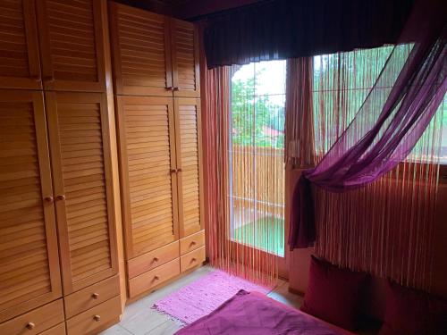 a bedroom with a window and a bed with purple curtains at JOKER Party House - Szigetszentmiklós in Szigetszentmiklós