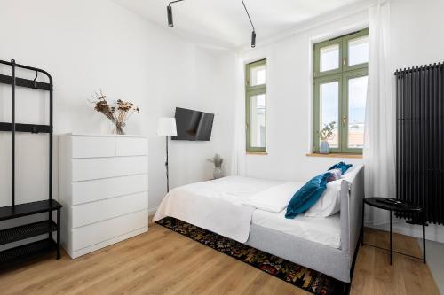 um quarto branco com uma cama e uma televisão em Homewell Apartments Poznańska em Poznań