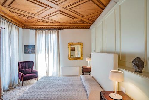 Schlafzimmer mit einem Bett mit Holzdecke in der Unterkunft Sartor Apartment with Canal View and Private Court in Venedig