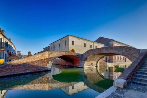 un puente sobre un río en una ciudad en Locanda della Pescheria en Comacchio