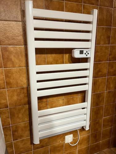 un porte-serviettes blanc sur le mur d'une salle de bain dans l'établissement Les grizzlis sur les pistes piscine tennis pétanque., aux Gets