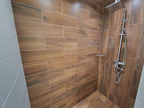 a bathroom with a shower with a wooden wall at Apartment on Belvedere in Ivano-Frankivsk