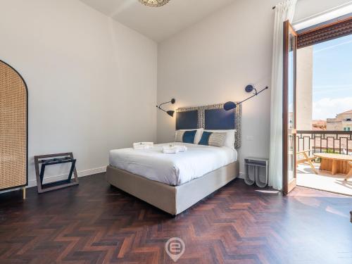 um quarto com uma cama grande e uma varanda em Verso Suite Cagliari - Charm in the City Centre em Cagliari