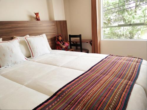 ein großes weißes Bett in einem Zimmer mit Fenster in der Unterkunft Dreams Boutique Hotel Cusco in Cusco